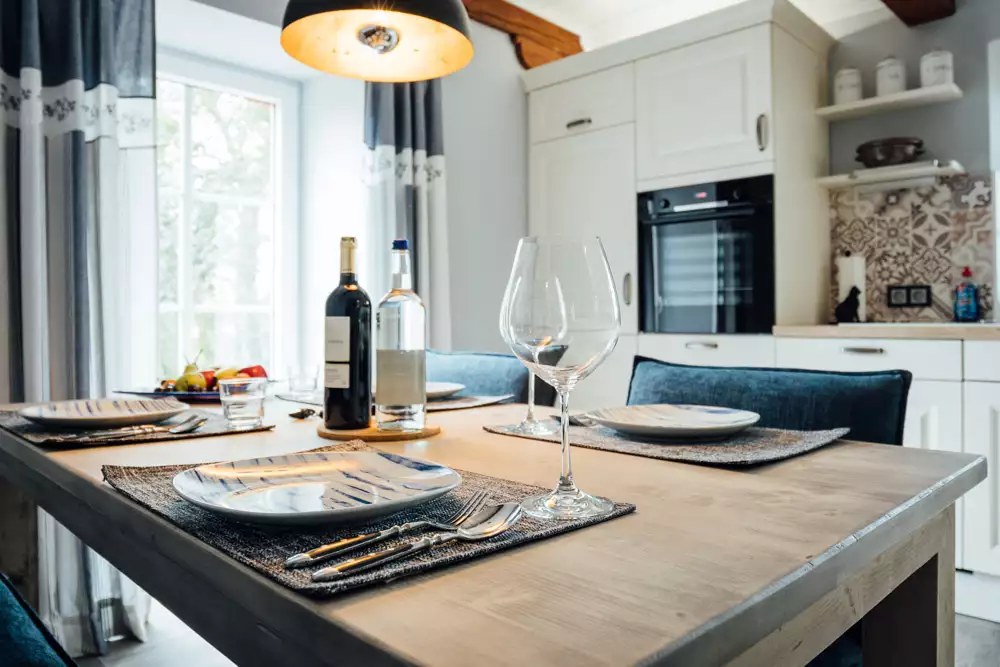 Gedeckter Esstisch für zwei mit Weinglas in einer modernen Ferienwohnungsküche auf Pellworm