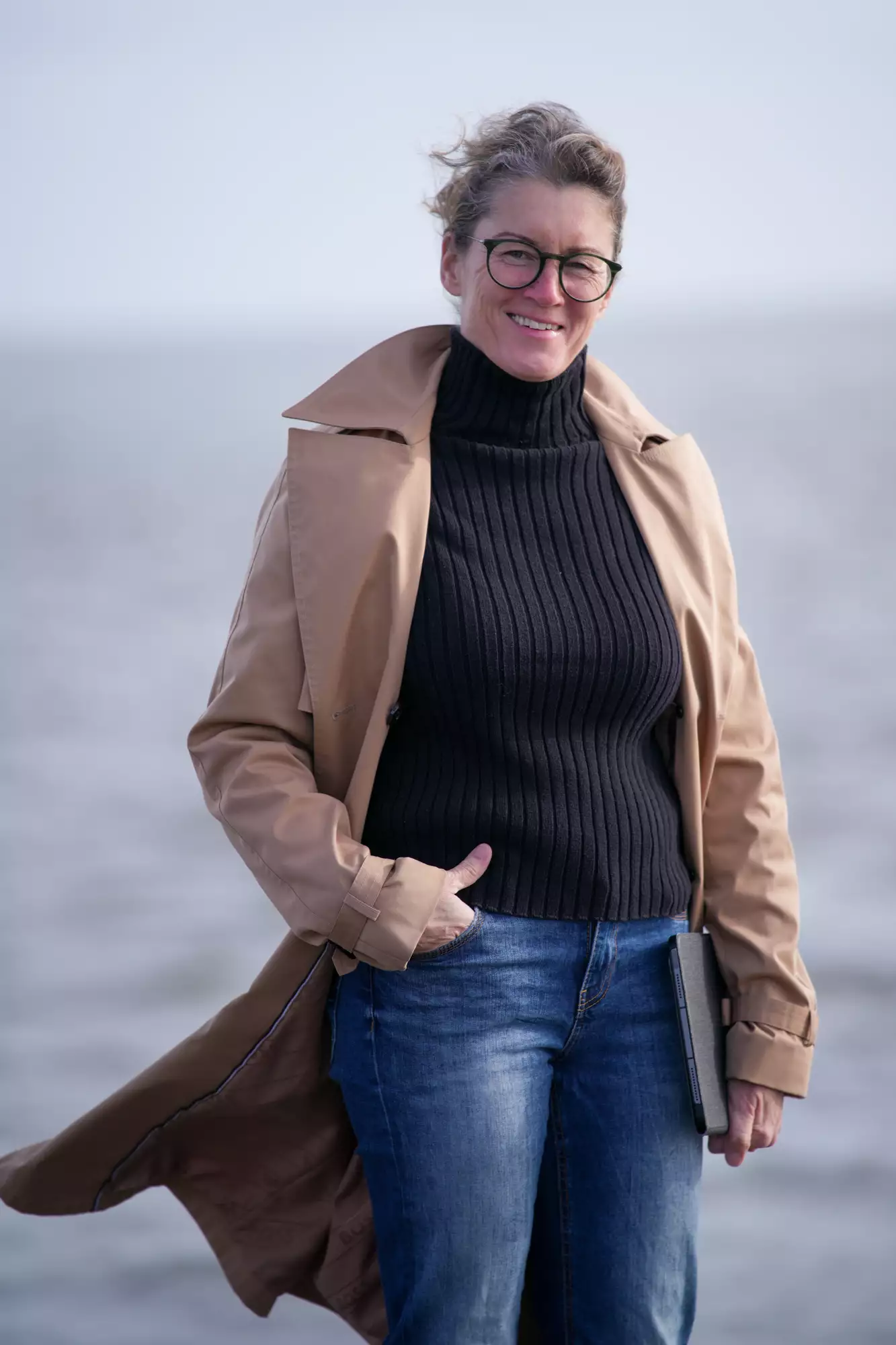 Porträt der Fotografin Ines Preißer im Trenchcoat an der Nordseeküste von Pellworm